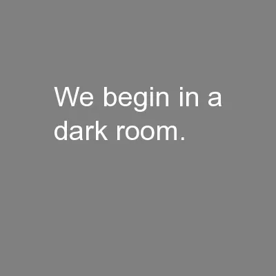 We begin in a dark room.
